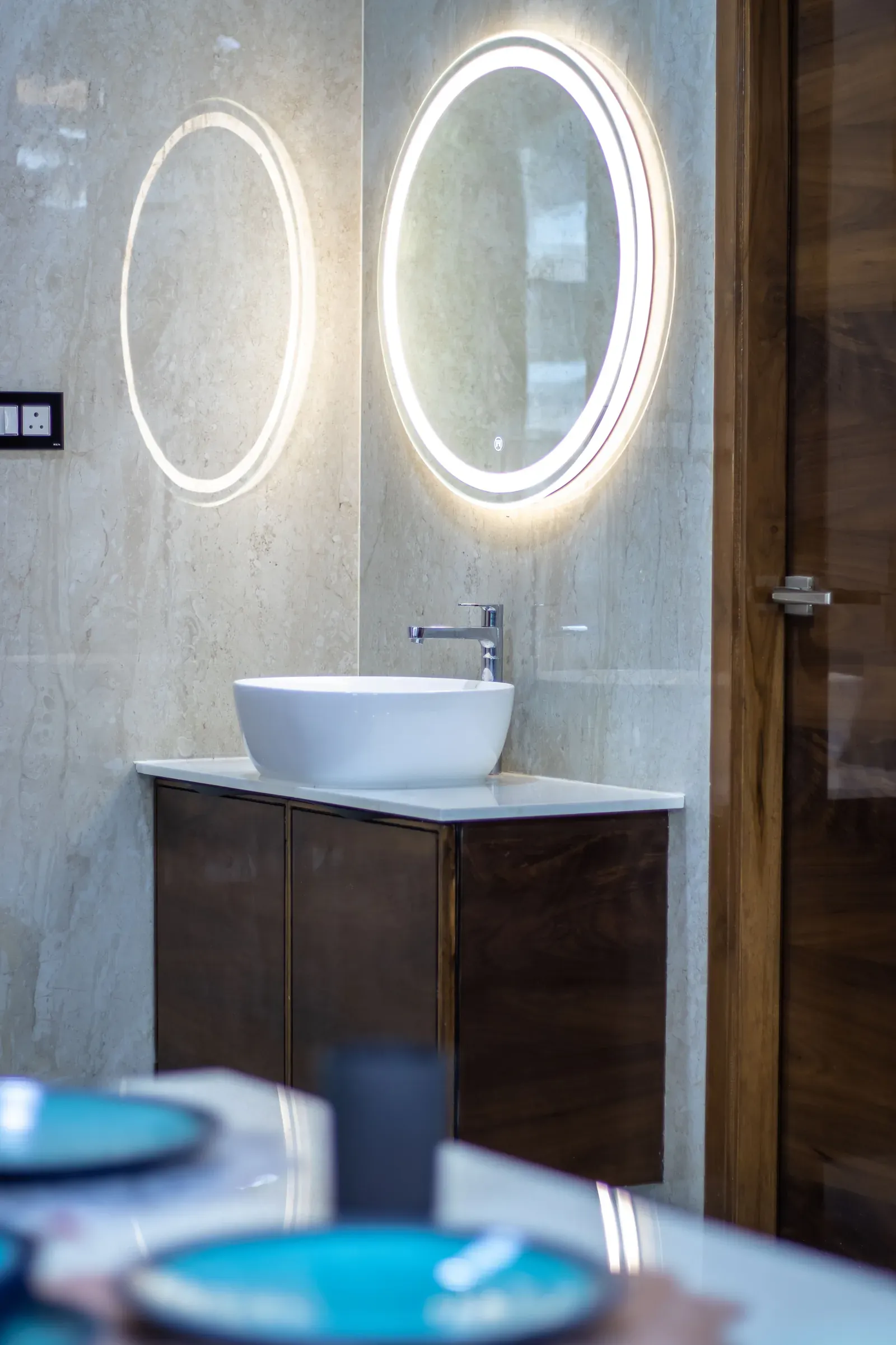 Walnut vanity with vessel sink and backlit round mirror
