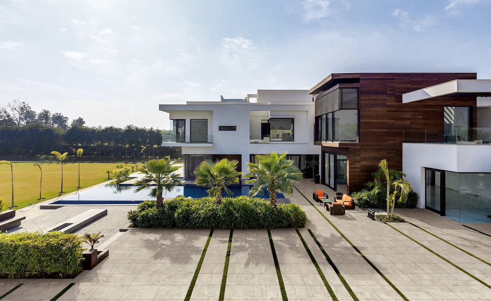 Large-format porcelain pavers with grass joints around a modern home