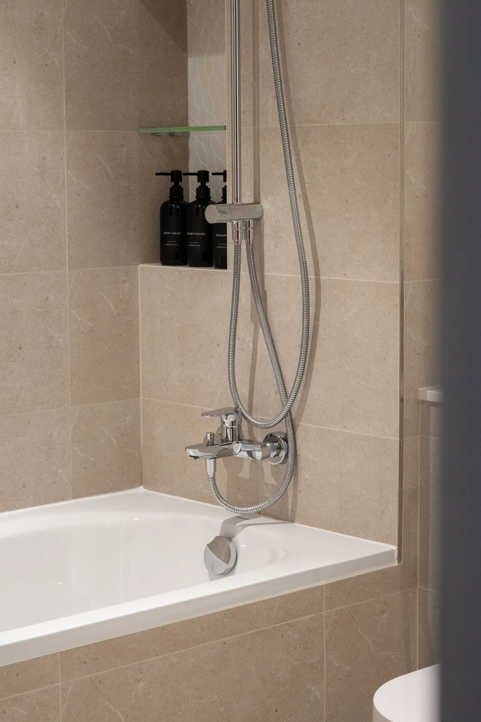 Large-format stone-look porcelain tile around a bathtub