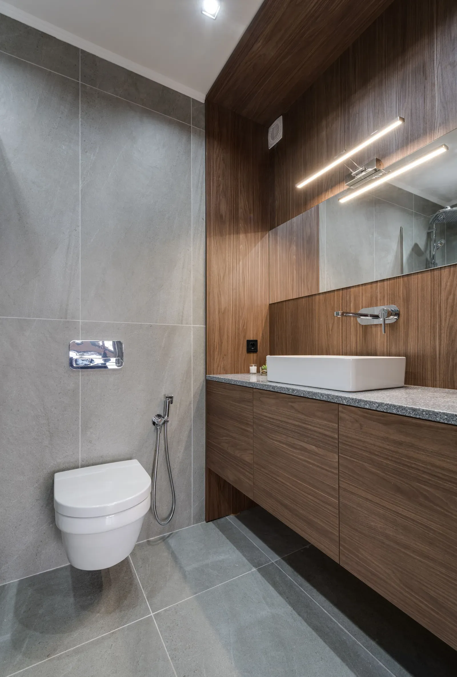 Floating walnut vanity with vessel sink and large porcelain tile