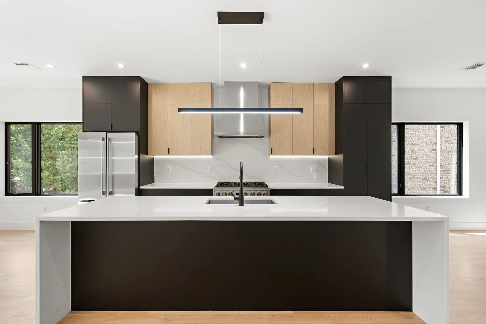 Modern black and white oak kitchen with marble-look waterfall island
