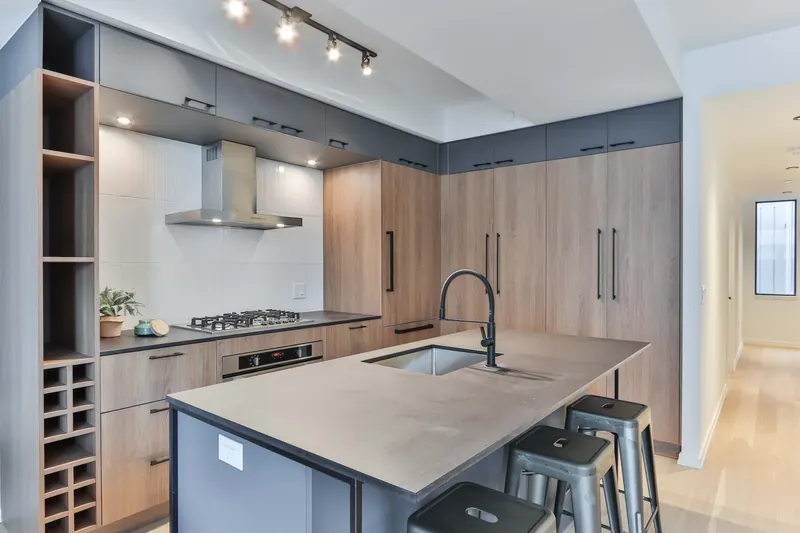 Walnut and gray kitchen in Manhattan, NY: Walnut and gray flat-panel cabinets, waterfall island