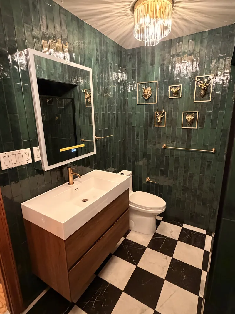 Green tile powder room in Demarest, NJ: Glazed green wall tile, black-and-white marble-look floor, floating walnut vanity