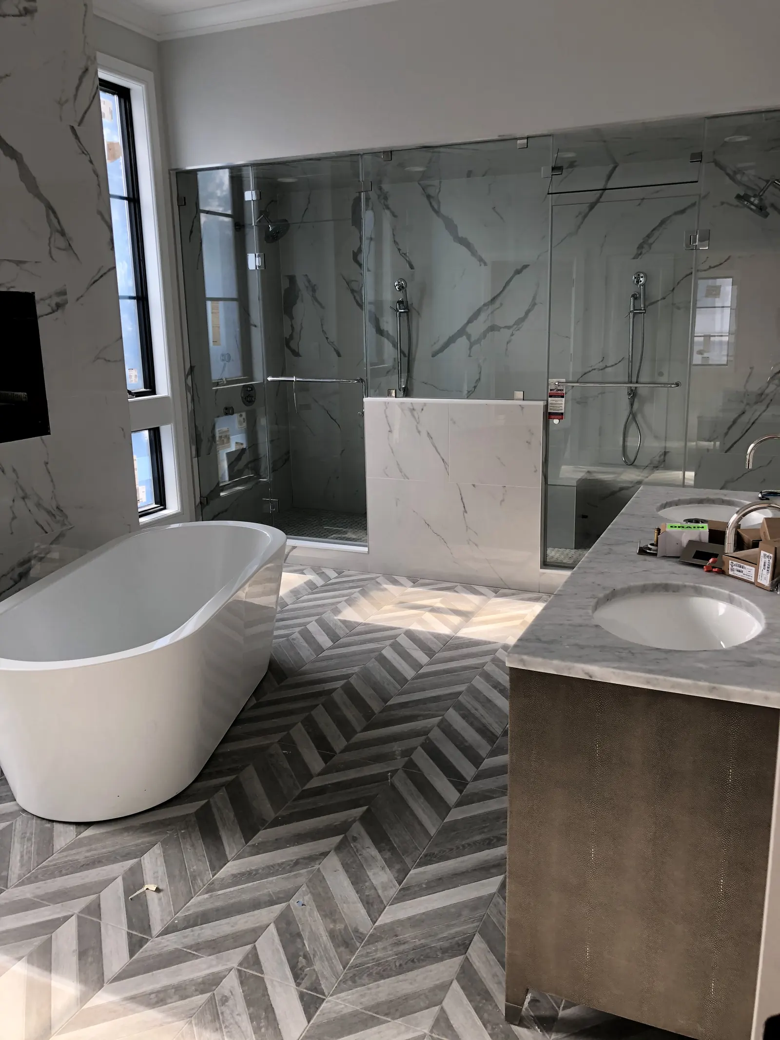 Primary bathroom with herringbone floor and freestanding tub