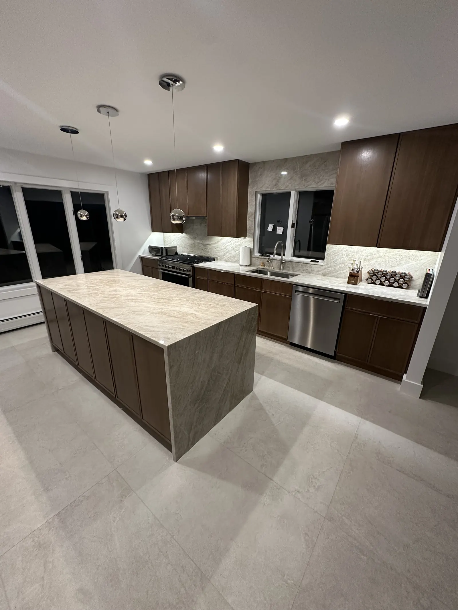 Walnut shaker kitchen with quartzite waterfall island and full-height backsplash