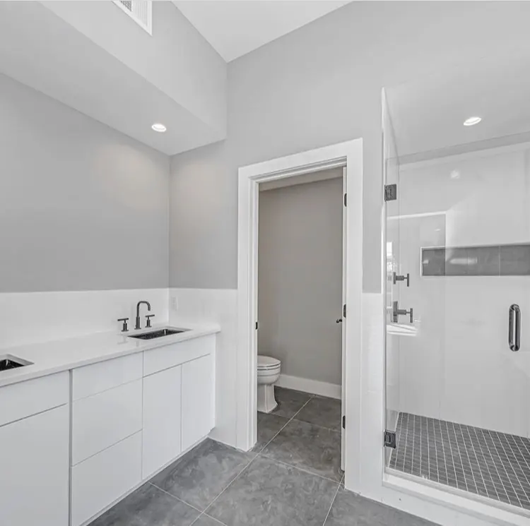 Glass shower with navy vanity and white tile