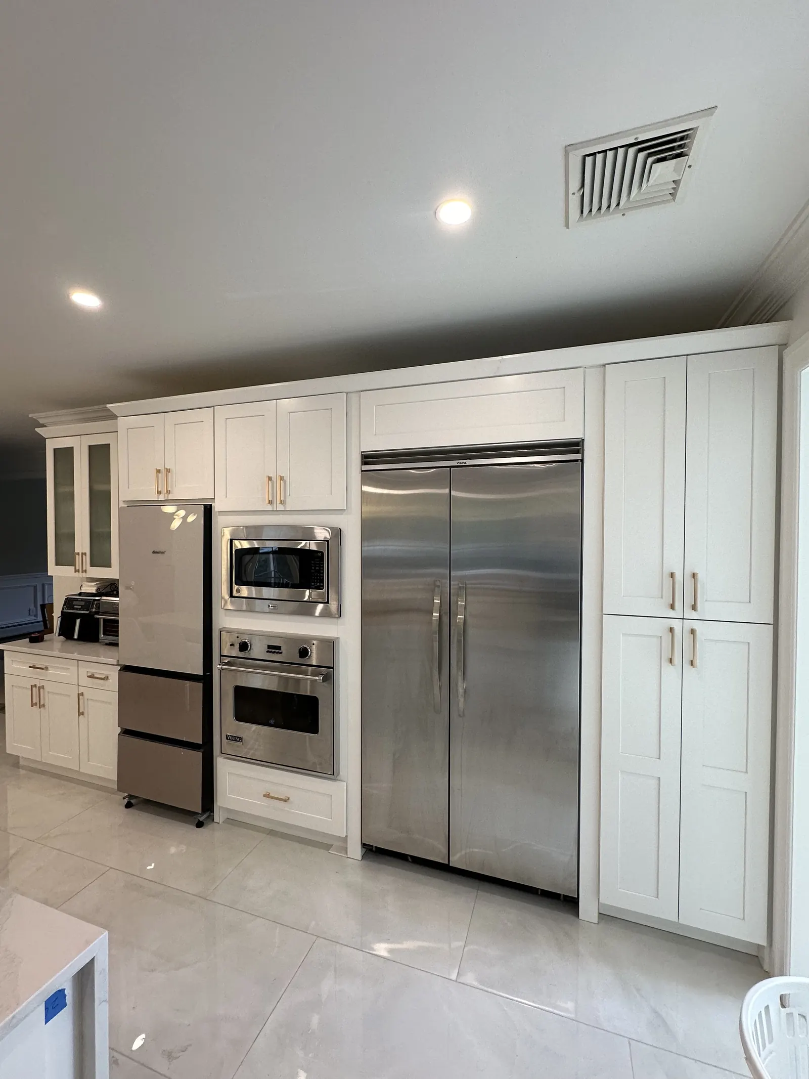 White shaker appliance wall with built-in refrigerator and ovens